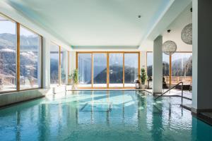 einen Pool in einem Gebäude mit Fenstern in der Unterkunft Hotel Ritzlerhof - Adults only in Sautens