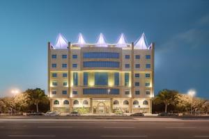 a large building with a pointed roof on a street at Konoz Al Yam Hotel Jeddah in Jeddah