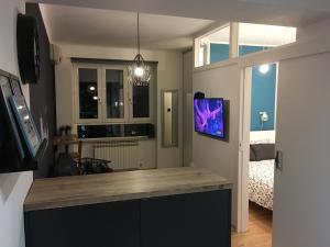 a living room with a counter with a tv on the wall at Apartman E5 in Zagreb