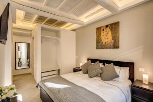 ローマにあるDimore Costagutiのベッドルーム1室(ベッド1台付)が備わります。壁には絵画が飾られています。