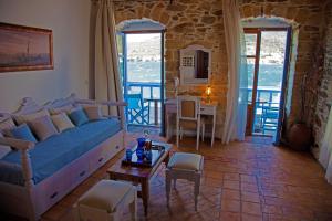 a living room with a blue couch and a table at Saint George Valsamitis Superior in Katapola