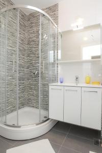 a bathroom with a shower and white cabinets at Apartments Tomana in Novalja