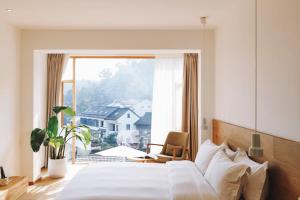 杭州Hangzhou Moju Boutique Guesthouse at the West Lake的一间带床和大窗户的卧室