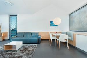 ein Wohnzimmer mit einem blauen Sofa und einem Tisch in der Unterkunft Apartamenty Laguna Boulevard by Renters Prestige in Ustronie Morskie