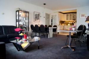 a living room with a couch and tables and chairs at The Studio Guesthouse in Volendam