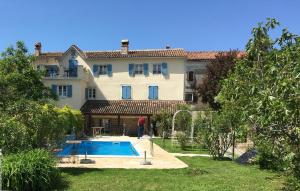 a man standing in front of a house with a swimming pool at Terra Mirna - Urlaub für die Sinne in Vižinada