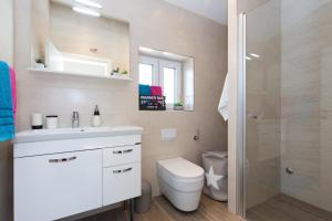 uma casa de banho com um WC, um lavatório e um chuveiro em Tamburika colorful apartment in rustica area em Krk