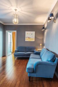 a living room filled with furniture and a blue couch at Triton Park Apartments in Warsaw