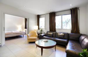 un soggiorno con divano in pelle e tavolino da caffè di Apartamentos Calvet a Barcellona