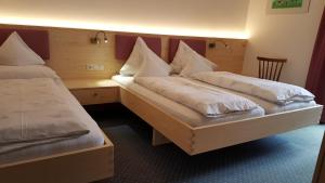 two twin beds in a room with a desk at Hotel Pension Moarhof in Vallarga