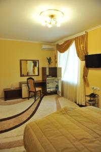 um quarto com uma cama, uma secretária e uma janela em Andinna Hotel em Chernivtsi