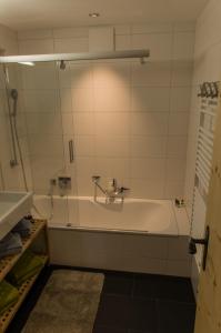 a bathroom with a bath tub and a shower at Apartments Les Marmottes in Zermatt