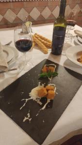 a table with a plate of food and a glass of wine at Agriturismo Alla Strozza in Voghenza