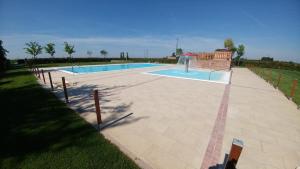 a swimming pool in a yard next to a fence at Agriturismo Alla Strozza in Voghenza
