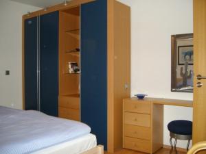 una camera da letto con parete blu, scrivania e letto di Haus Kollwitzweg - Ferienwohnungen a Goslar