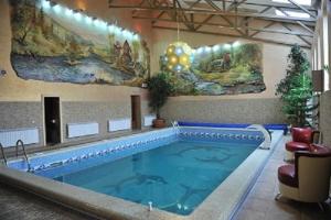 a large swimming pool in a building with a large swimming pool at Andinna Hotel in Chernivtsi