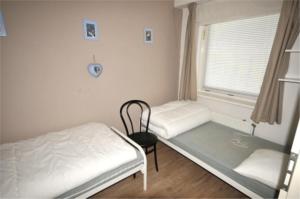 ユリアーナドルプにあるAppartement 121のベッドと窓が備わる小さな客室です。