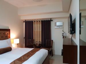 Pokój hotelowy z łóżkiem i biurkiem w obiekcie Studio Unit at The Beacon Makati w mieście Manila