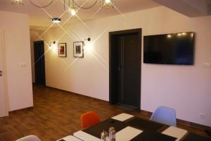 プルシュクフにあるObiekt Noclegowy OCELOTのテーブルと椅子、薄型テレビが備わる客室です。