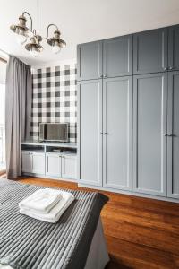 a room with a bed, a dresser and a mirror at Triton Park Apartments in Warsaw