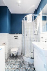 a bathroom with a shower and a toilet and a sink at Triton Park Apartments in Warsaw +30 photos