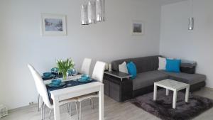 a living room with a couch and a table at BTS Apartaments - Apartamenty Blisko Morza in Gdańsk