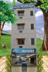 a hotel building with a deer standing in front of it at Hotel Madhava in Shirdi