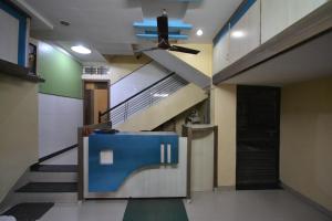 a hallway with a staircase and a ceiling fan at Hotel Madhava in Shirdi