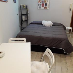 ナポリにあるMini Loftのベッドルーム1室(ベッド1台、テーブル、椅子付)