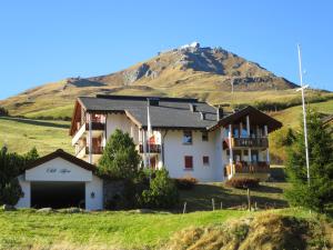 ein Haus mit einem Berg im Hintergrund in der Unterkunft Chli Alpa B13 in Arosa