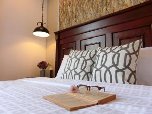 a tray with a pair of glasses on a bed at Bloom Boutique Hotel & Cafe in Vientiane