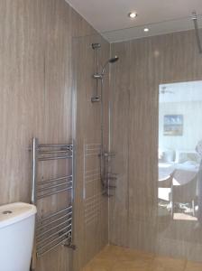a shower with a glass door in a bathroom at The Stables self catering in Seahouses