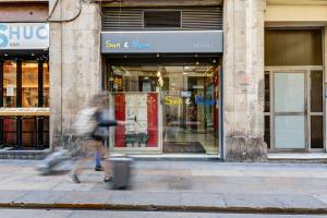 a person walking down a street in front of a store at Sun & Moon Hostel in Barcelona