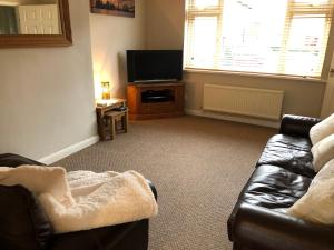sala de estar con sofá y TV en Comfortable House in Warwick, en Warwick