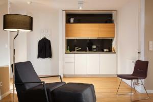 ハンブルクにあるSMARTments business Hamburg Aussenalsterのリビングルーム(ソファ、椅子2脚付)