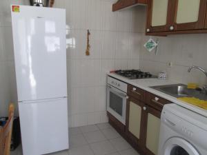 カルヴォエイロにあるApartamento na Praiaのキッチン(白い冷蔵庫、シンク付)