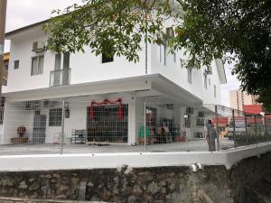 a white building with cages in front of it at Connaught Guest House 康乐民宿 in Kuala Lumpur