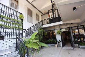 um edifício com escadas e plantas em frente em Bloom Boutique Hotel & Cafe em Vientiane