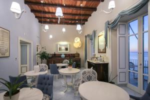 a room with tables and chairs and a view of the ocean at Palazzo Mottola Tropea in Tropea