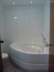 La salle de bains est pourvue d'une baignoire blanche et de toilettes. dans l'établissement VIP Apartment Baden-Baden, à Baden-Baden