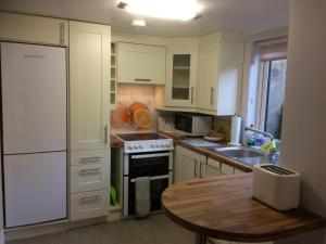 a kitchen with white cabinets and a wooden table at The Tailors in Ballyfarnon