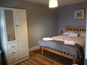 sypialnia z łóżkiem z komodą i lustrem w obiekcie The Tailors w mieście Ballyfarnon