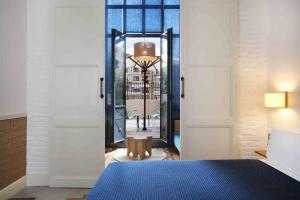 a bedroom with a blue bed and a mirror at Hotel Casa Bonay & Spa in Barcelona