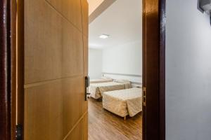 an open door to a room with two beds at Cardim Plaza Hotel in Sao Paulo