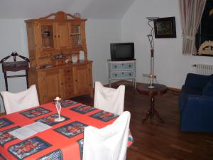 ein Wohnzimmer mit einem Tisch und einem TV in der Unterkunft Schlosshotel Bredenfelde in Bredenfelde