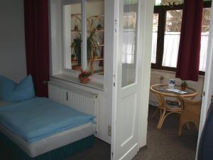 Kleines Zimmer mit einem Bett und einem Tisch in der Unterkunft Pension Zum Burschen in Eisenach