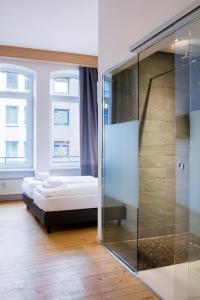 科布倫茨的住宿－叮噹科布倫茨城市公寓式酒店，一间卧室设有一张床和一个玻璃淋浴间