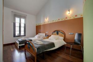 sypialnia z dwoma łóżkami i krzesłem w obiekcie Holiday House Tenorio w mieście Ronda
