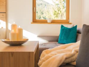 ein Wohnzimmer mit einem Sofa und einem blauen Kissen in der Unterkunft Chavida Chalets in Schattwald