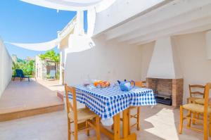 uma sala de jantar com uma mesa e cadeiras e uma lareira em Can Salas em Porreres